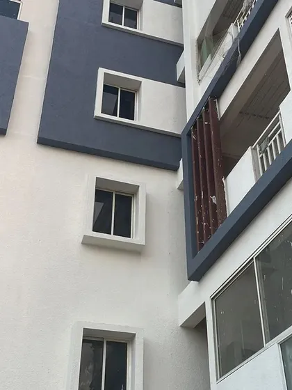 The completed exterior of a modern residential building, featuring a clean two-tone color scheme in grey and white. Our exterior painting services enhance curb appeal and protect the building from the elements.