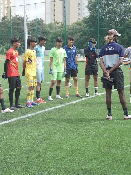 Young goalkeepers listen attentively to their coach before starting a new drill. We focus on building a strong foundation of goalkeeping fundamentals.