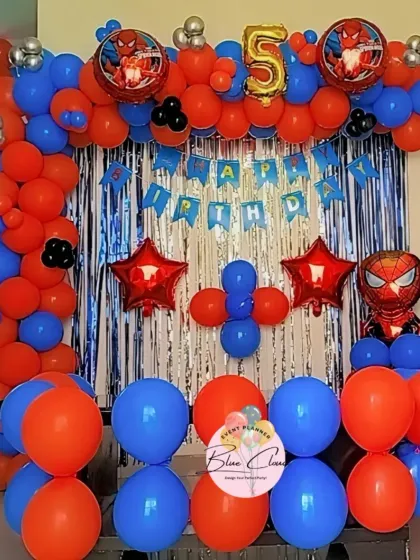A classic Spiderman theme for a 5th birthday, with a red and blue balloon arch and a shimmer curtain.