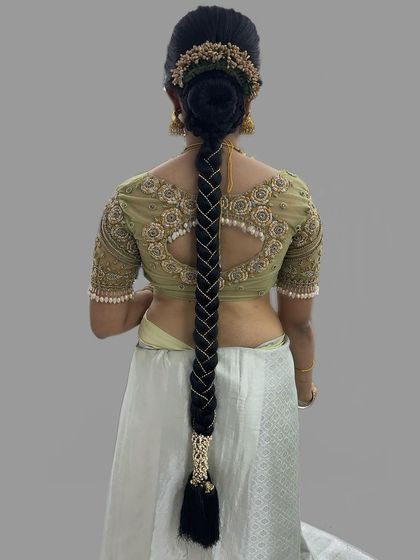 A close-up of a pearl-adorned traditional braid. The intricate pearl detailing adds a touch of modern elegance to this classic Muhurtham hairstyle.