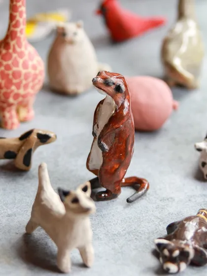 A proud meerkat stands among other miniature animals, each piece a testament to the creativity of our workshop attendees.