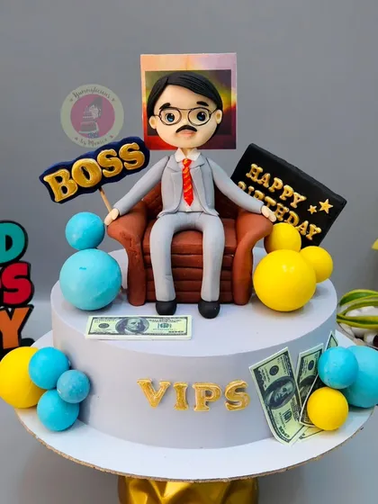A fun cake for a boss, featuring a custom figurine, money details, and a "BOSS" sign.