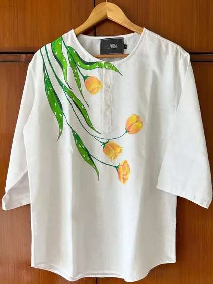 Art isn't just for walls. I hand-painted these delicate yellow tulips on a simple white linen kurta, creating a piece of unique wearable art. If you have a favorite garment, we can transform it into something truly special.