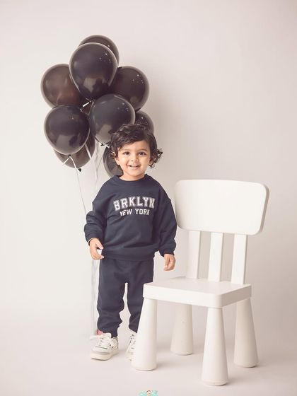 A modern and stylish 18-month shoot. The simple white background and casual outfit create a portrait that feels both candid and polished.