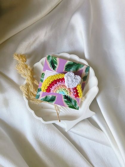 A single crochet rainbow clip with a little heart cloud, beautifully presented in a shell-shaped dish.