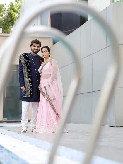 A creative shot using foreground elements to frame the couple. This technique adds depth and an artistic feel to your pre-wedding photos.