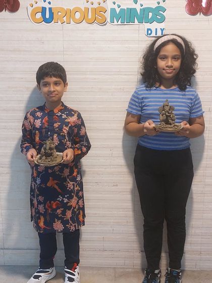 Brother and sister proudly holding the eco-friendly Ganesha idols they made together in our workshop. It’s a wonderful bonding activity for siblings.