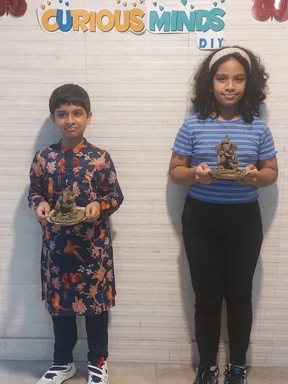 Two siblings proudly display their handmade Ganesha idols. Our workshops are a great activity for families to bond and celebrate their culture and creativity together.