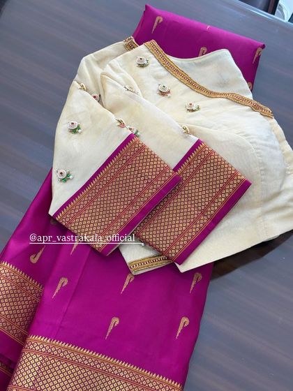 The back of the off-white blouse, featuring a simple neckline.