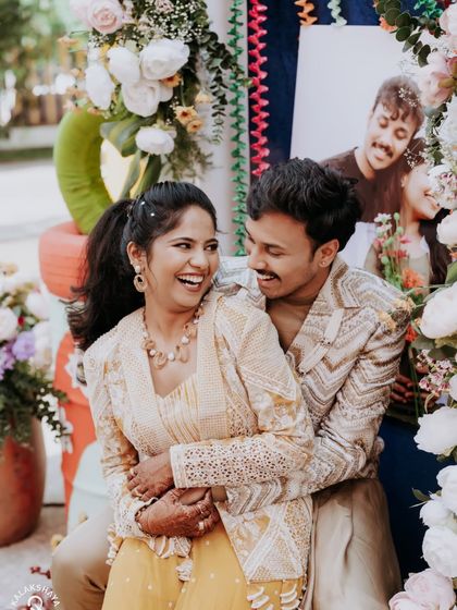 A candid moment of laughter between the couple at their colorful carnival-themed party.