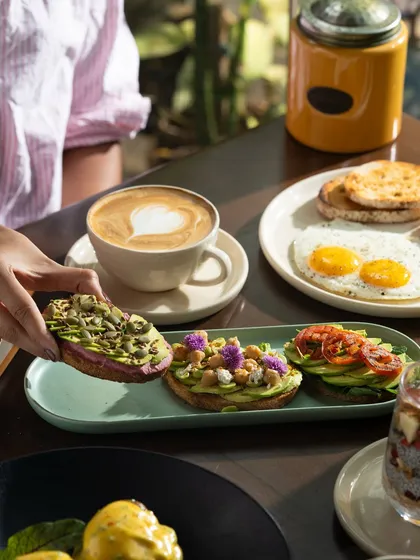 A healthy and colorful brunch spread featuring avocado toast trio and sunny-side-up eggs.