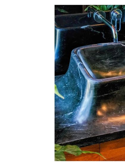 A custom-sculpted sink in black marble. The fluid lines and polished surface are a result of skilled craftsmanship, turning a utilitarian object into a centerpiece.