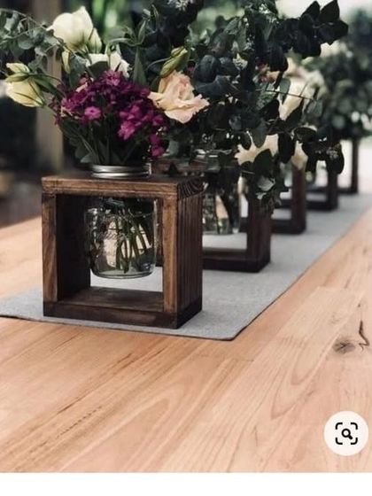 These rustic wooden box centerpieces with flowers are an example of our custom decor items. They are perfect for adding a natural, farmhouse-style touch to a dining table or event.