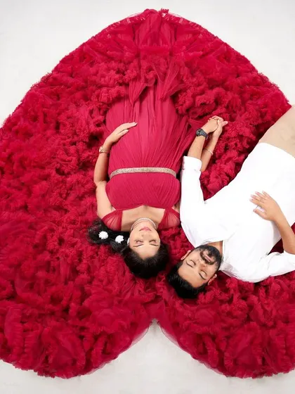 A creative top-down shot with the red gown spread out to form a heart shape. This popular and artistic pose is a beautiful way to symbolize the love for the new baby.
