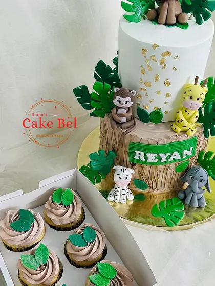 The jungle cake paired with matching cupcakes with green frosting and leaf toppers.