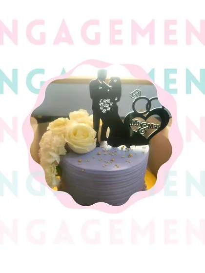 A simple yet beautiful engagement cake. The soft lavender icing is complemented by fresh white roses and a classic "Mr & Mrs" topper, creating a sophisticated and heartfelt cake for the happy couple.