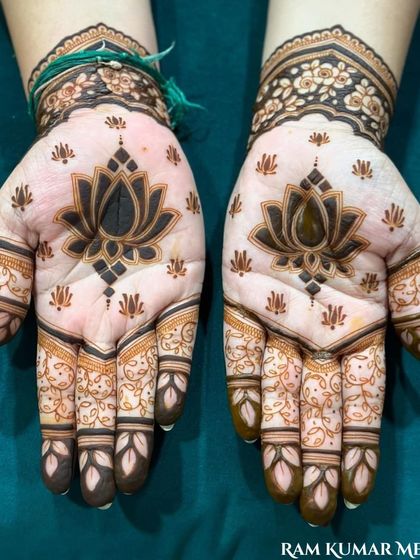 A bold and beautiful design featuring a large lotus on the palm. The simplicity of the palm contrasts wonderfully with the detailed patterns on the fingers.