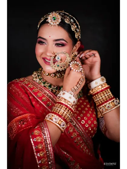 The joy of a bride on her special day. This candid shot captures the radiant makeup and the intricate details of the bridal attire.