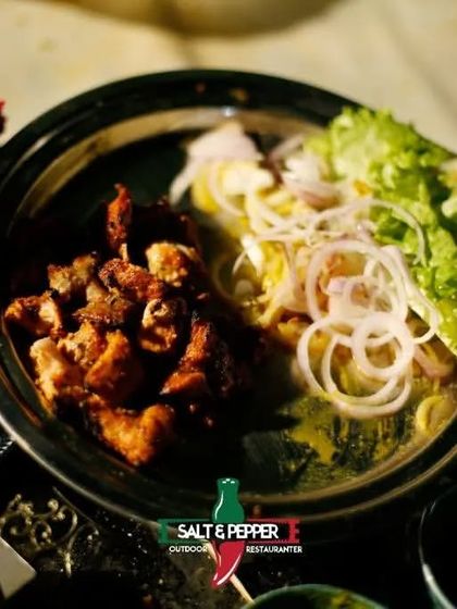 A beautifully plated dish of crispy fried chicken served with fresh lettuce and onion rings. This appetizer is both delicious and visually appealing.