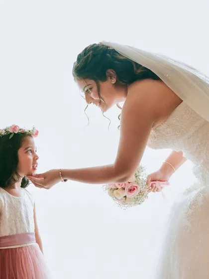 A tender moment between the bride and her flower girl. The soft, natural makeup looks beautiful in these heartfelt, candid shots.