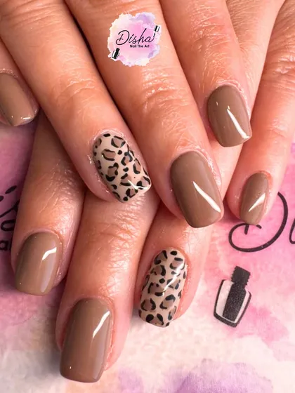 A simple yet chic design with a solid brown base and a classic leopard print accent nail.
