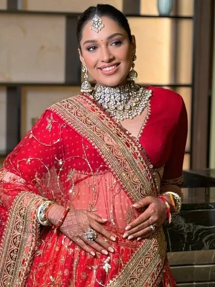 The quintessential bridal look for a Sabyasachi bride, featuring a clean, sleek center-parted bun. This is a timeless and regal hairstyle that provides a perfect canvas for a statement maang tikka and dupatta.