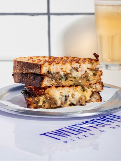 Our Cheesy Mushroom Melt sandwich stacked and ready to be devoured, perfect with a cold drink on the side.