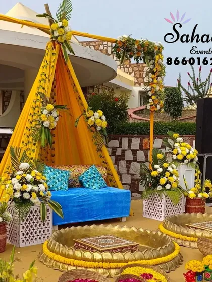 We bring vibrant energy to Haldi ceremonies with creative setups like this. This outdoor arrangement features a stylish teepee seating area, traditional brass urlis, and bright marigold flowers, perfect for a fun and colorful pre-wedding celebration.