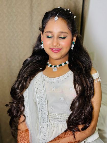 A close-up with eyes closed, highlighting the subtle eye makeup.