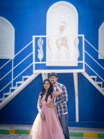 This couple's outfits perfectly complement the bright blue and white of the Santorini-themed studio set, creating a picture-perfect moment.