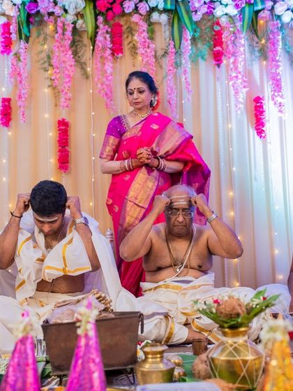 A moment from a Tamil Brahmin wedding ceremony, showing the priests and family members involved in the rituals.