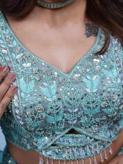 A close-up of the detailed sequin and beadwork on our sky-blue lehenga blouse. It's a work of art.