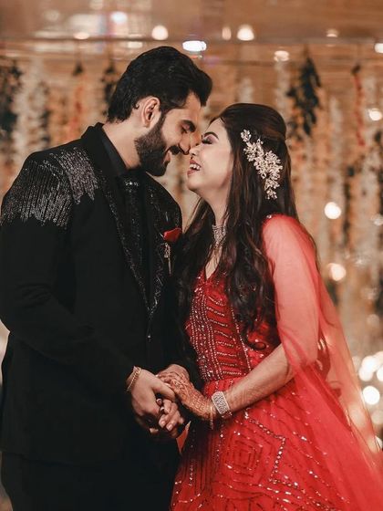 A beautiful, intimate moment between a couple. The groom's custom black suit with silver embroidery perfectly complements the romantic setting.