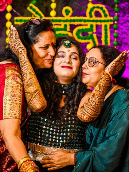 A heartwarming moment as the bride is embraced by her family during the Mehndi ceremony. These emotional connections are a key part of the story we tell.