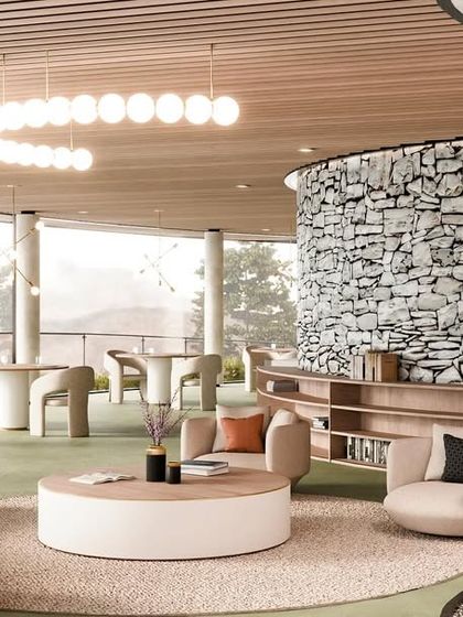 The resort's lounge area features curved sofas, a natural stone wall, and a large circular light fixture, creating a sophisticated yet comfortable space.