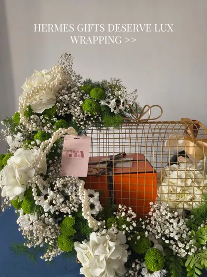 When the gift inside is from a brand like Hermès, the presentation has to be just as luxurious. I created this grand setting using a golden cage structure, overflowing with fresh white hydrangeas, chrysanthemums, and baby's breath.