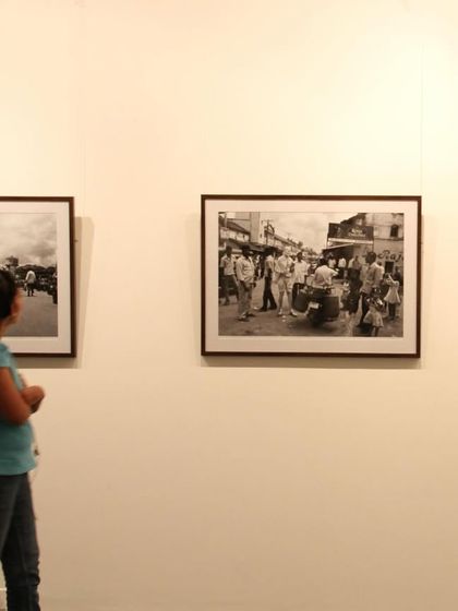 A visitor contemplating the documentary-style photographs from Cop Shiva's early work.