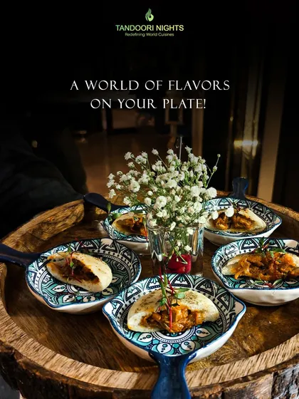 We bring a world of flavors to your plate. These mini pita pockets, filled with pulled masala jackfruit, are served in beautiful ceramic dishes on a rustic wooden platter.