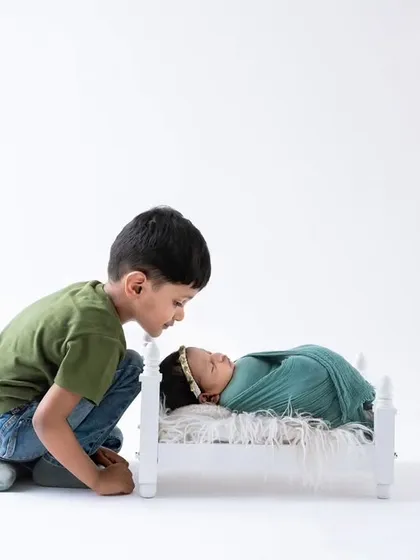 A slightly different angle of this precious moment, showing the big brother's curiosity and gentleness. I always aim to capture multiple perspectives of these fleeting interactions.