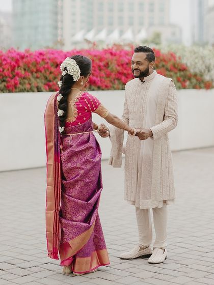 A first look moment at a Tamilian wedding. The groom's blush sherwani perfectly complements the bride's traditional hot pink saree, a testament to our focus on cultural and color balance.