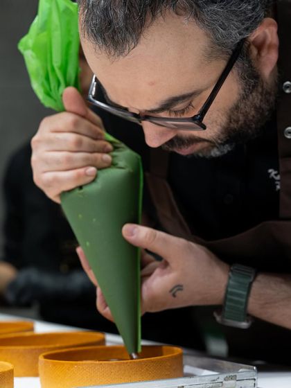 A close-up of Chef Karim Bourgi's focused piping work.