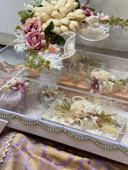 An acrylic trunk filled with beautifully arranged gifts. This modern approach to trousseau packing is perfect for showcasing multiple items while keeping them protected and stylishly displayed.