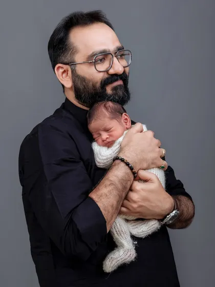 A father's gentle embrace. A dad holds his sleeping newborn close in this touching and heartfelt portrait.