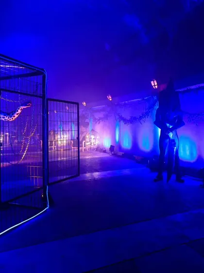 The entrance to the 'Avatar' themed party, with moody blue lighting and caged structures, setting a mysterious and exciting tone for the night.