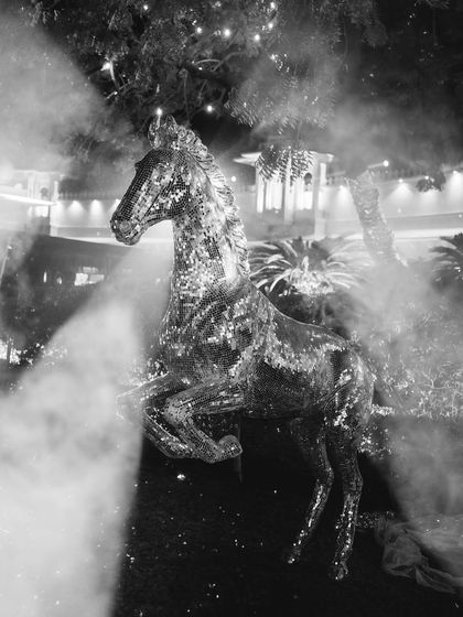A sparkling horse statue emerges from a cloud of smoke, a dramatic and unexpected decor element that added to the high-energy, glamorous vibe of the disco night.