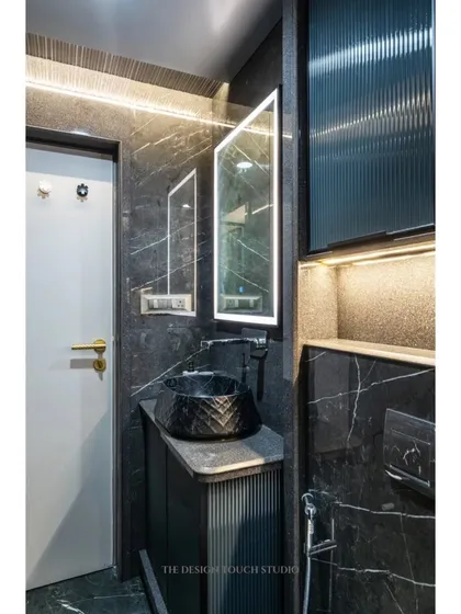 Another angle of the bathroom, highlighting the textured black vessel sink and the elegant, minimalist fixtures.