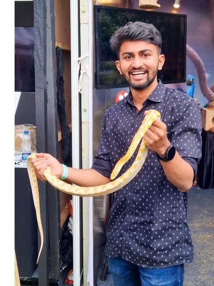 A duplicate of me holding a snake at Pet Fed 2023. I'm always up for a new experience.