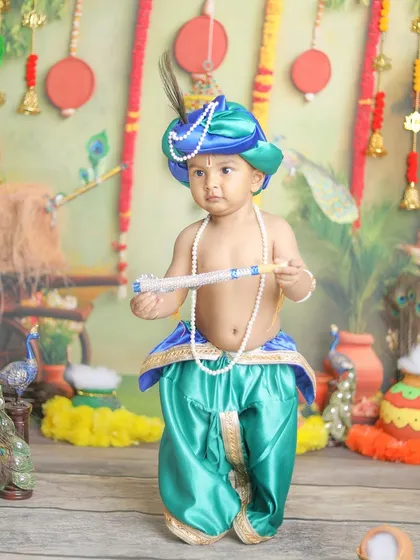 A full-length portrait showcasing the beautiful teal and blue costume against the festive backdrop.
