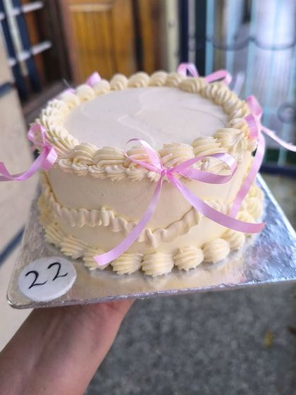 I love getting to make these lovely, Pinterest-y cakes. This design features delicate, vintage-style piping and is adorned with simple pink ribbons for a coquette-chic look.