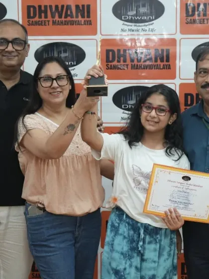 A family celebrates their daughter's success at the Dhwani Kala Mahotsav.